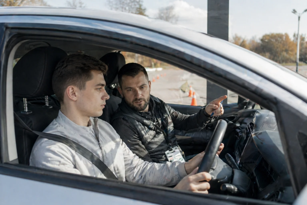 Ученик за рулём учебного автомобиля на занятии по вождению в автошколе в Тюмени